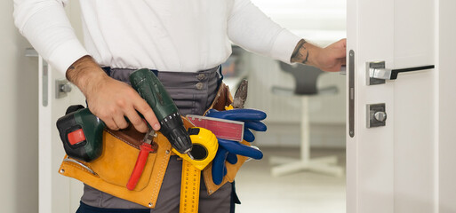 Handyman Fitting A New Door Using A Screwdriver At Home