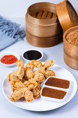 Batagor,(Fried Tofu Meatballs), served on a serving plate with peanut sauce, sambal, and chili sauce. This is authentic street food from Bandung Indonesia. Perfect for recipes, articles or any cooking