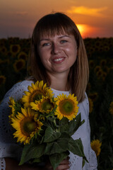 Beautiful young girl in a white dress in sunflowers