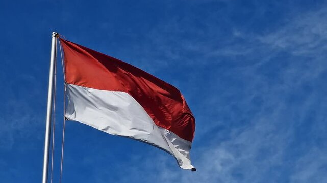 The Indonesian flag, the Red and White Flag, the national symbol of Indonesia. The Indonesian flag flutters in the blue sky. the 79th Independence Day of the Republic of Indonesia. Red and White Flag.