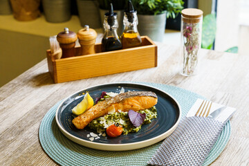Fried salmon with lemon, asparagus, broccoli, scallions