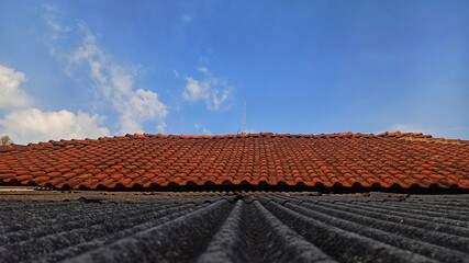 roof tiles made of earth on a bright blue sky background. Building