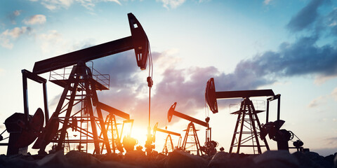 Silhouetted oil pumps against a twilight sky. Oil industry