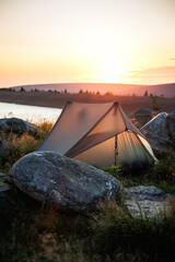 Camping in mountains by lake at sunrise. Ultralight tent for solo hiking. Outdoors adventure © encierro