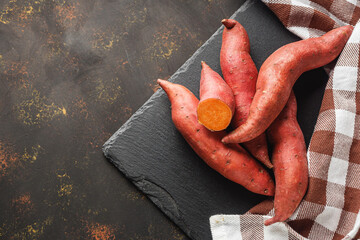 fresh sweet potatoes on a dark rustic background