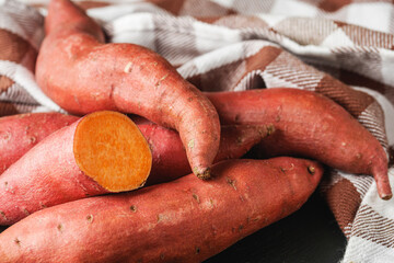 fresh sweet potatoes on a dark rustic background