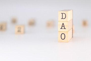 DAO Acronym - Concept of Decentralized Autonomous Organizations written on wooden cubes isolated on white background with copy space for the text 