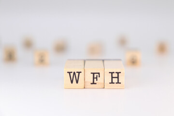 WFH acronym - Concept of Work From Home written on wooden cubes isolated on white background with copy space for text phrase.

