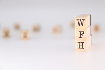 WFH acronym - Concept of Work From Home written on wooden cubes isolated on white background with copy space for text phrase.

