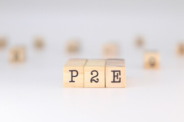 P2E acronym - Concept of Play to Earn written on wooden cubes on white background with copy space.