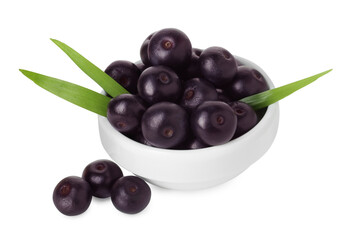 Fresh ripe acai berries in bowl and green leaves isolated on white