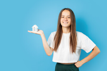 Obraz premium Mortgage sell, teenage girl with house, curly-haired teenager with new property, teen's first real estate purchase