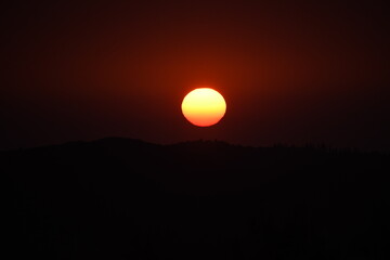 Epic sunset landscape sky with big bright sun going behind the mountains in Corfu,Greece,Europe