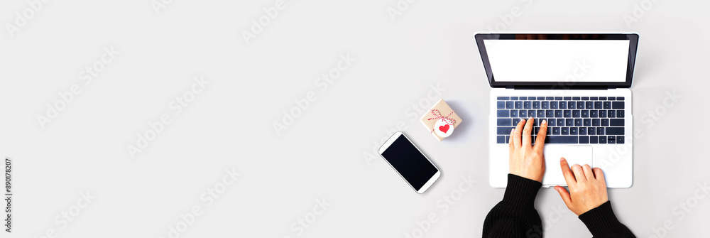 Poster person using a laptop computer with a small gift box from above