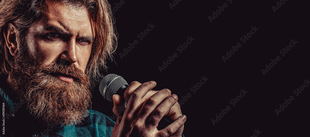 Wall mural male singing with a microphones. man beard holding a microphone. male singing with a mic