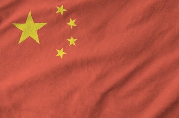 China flag depicted on folded wavy fabric of old cloth close up