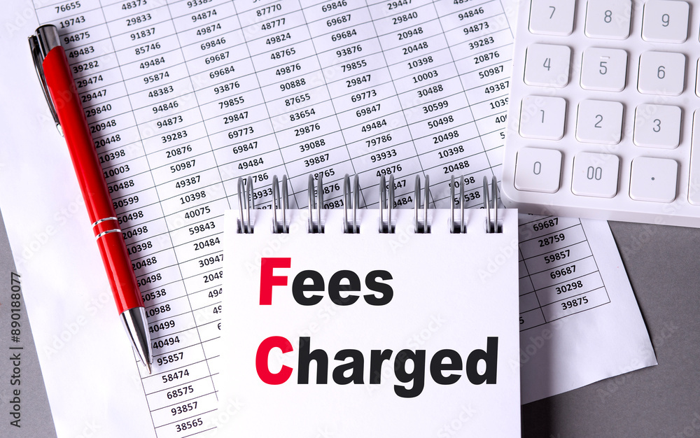 Poster fees charged text on notebook with chart , pen and calculator