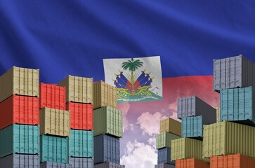 Haiti flag and big stack of shipping cargo containers in docks with sky background close up