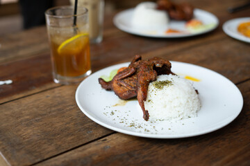Fried quail served with spicy sambal and rice, showcasing a delicious traditional meal, perfect for food, culture, and culinary