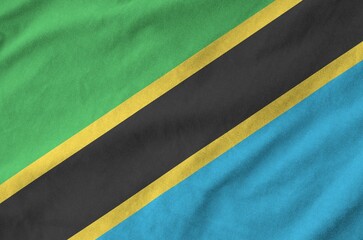 Tanzania flag depicted on folded wavy fabric of old cloth close up