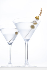 Vodka martini cocktail with vodka and vermouth and green olives isolated on white background