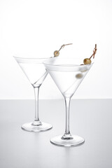 Vodka martini cocktail with vodka and vermouth and green olives isolated on white background