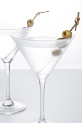 Vodka martini cocktail with vodka and vermouth and green olives isolated on white background