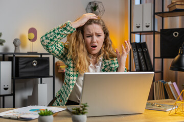 Displeased sad blonde woman using laptop notebook typing browsing working loses becoming surprised sudden lottery results bad news fortune loss game fail computer virus. Caucasian girl at home office