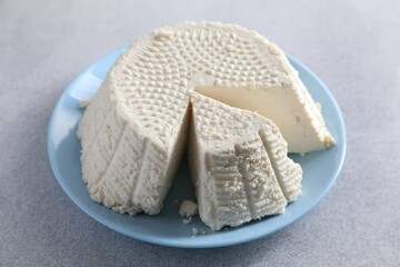 Tasty ricotta (cream cheese) on grey table