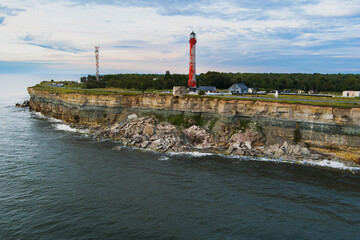 Sea steep cliff and lighthouse in Paldiski peninsula on a summer evening, photo taken from a drone.