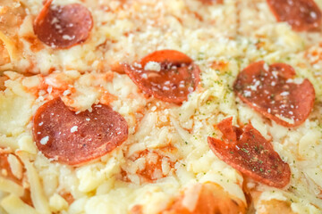 Macro photography of Freshly cooked Italian pizza with various cheese and sausage toppings in ceramic plate on wooden table. Empty blank copy text space.