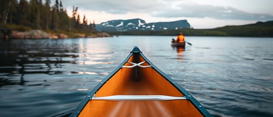 A canoe is in the water with a man in an orange life jacket