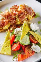 toast with scramble and bacon on a white plate