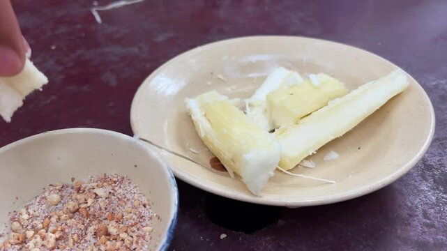 Peanuts and cassava Handheld shallow depth of field shot of tapioca root snack with peanut sugar at Cu chi Tunnels in Vietnam