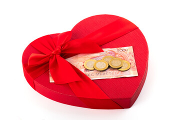 Gift box in the shape of a human heart symbol and a new 5,000 Kazakhstani tenge banknote