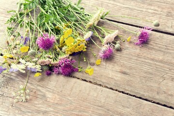 Colorful bouquet of meadow flowers on chalkboard background with empty space. Summer solstice bouquet. Top view, shallow depth of field.