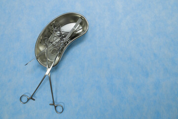 Stainless medical equipment used by surgeons in surgery placed on a blue background. Surgical...