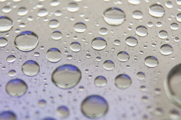 Close up of droplets on clear glass on dark background. Suitable for design and wallpaper