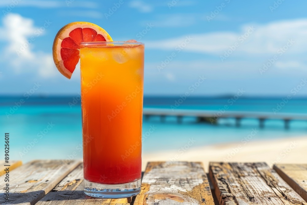 Poster refreshing tropical drink with a grapefruit slice set against a serene beach background capturing th