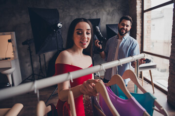 Handsome male stylist photographer working with model in studio creating outfit for photo together...