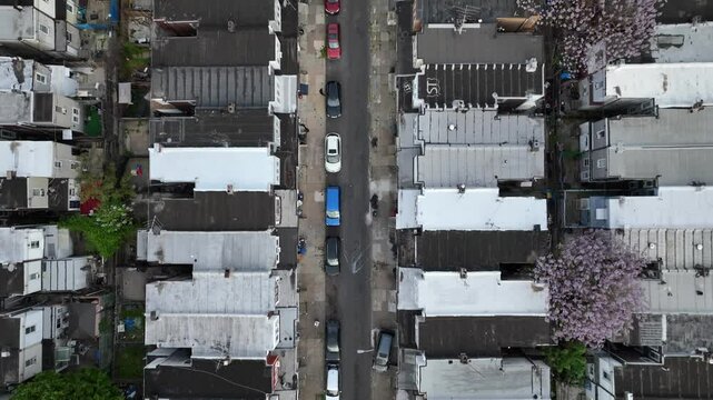 Top down aerial of run-down row houses in American city during spring. Dangerous USA neighborhood.