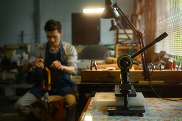 A special press machine on wooden table in a local workshop. Workplace for shoemaker