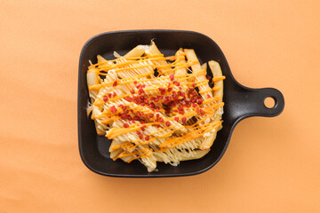 French Fries topping with Cheddar Cheese served in dish isolated on background top view of fastfood potato chips