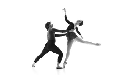 Fluid and synchronized. Ballet partners during practice against white studio background. Black and white filter. Concept of pair training, classic ballet, inspiration, beauty, creativity. Ad.