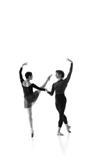 Elegance. Ballet duo harmonizes their movements during training against white studio background. Black and white filter. Concept of pair training, classic ballet, inspiration, beauty, creativity. Ad.