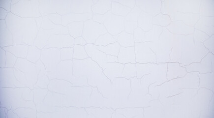 Wallpaper texture for background and design. Peeling paint on the wall. White concrete wall with old cracked flaking paint. Weathered rough painted surface with patterns of cracks.