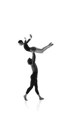 Elevated elegance. Young ballet dancer lifting ballerina harmonizing their moves against white...