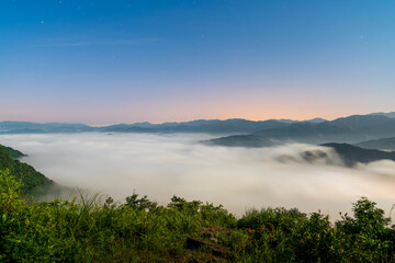 On a summer night, the sea of clouds surges. View of the mountains surrounding Emerald Reservoir. Xindian District, Taiwan.