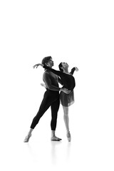 Talented young man and woman training, synchronizing their moves during practice session against...