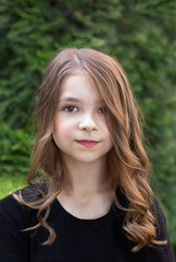 Fototapeta premium Fashion portrait of a beautiful little girl with makeup and hairstyle outdoors